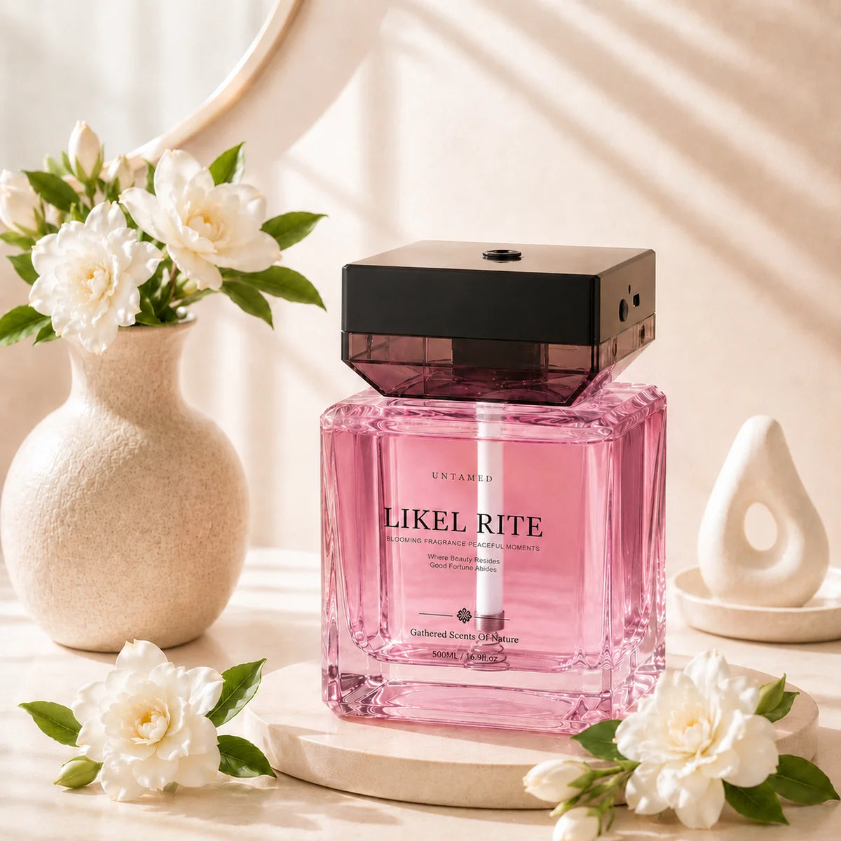 A pink scent diffuser beside white flowers in a sunlit interior